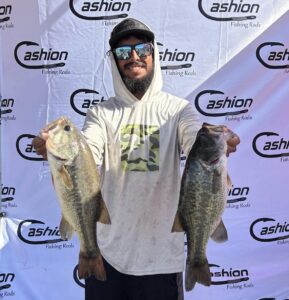 Mason Smook holding two of his kickers in front of the Cashion Banner at the Solo Series event at Bartlett Lake