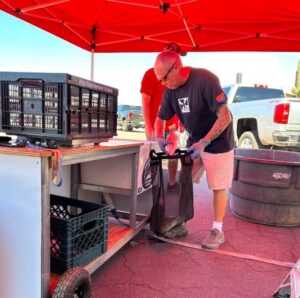 Tournament director Lyle transferring bass from the weigh station to the bags before weighing in.