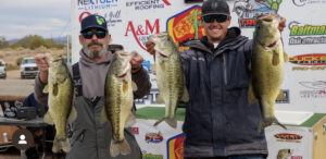 Mike Williams and Jerry Fisher holding their massive Largemouth in front of the weigh in trailer and Martinez Lake. 