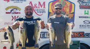 Doc David and Daniel Elias with their winning bag in front of the tournament trailer at Lake Pleasant