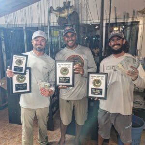 winner of the tournament holding cash and plaques